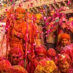 बरसाना में राधा रानी मंदिर परिसर में श्रद्धालुओं पर बरसते लड्डू, लड्डू मार होली का उत्सव दृश्य