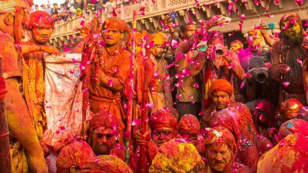 बरसाना में राधा रानी मंदिर परिसर में श्रद्धालुओं पर बरसते लड्डू, लड्डू मार होली का उत्सव दृश्य