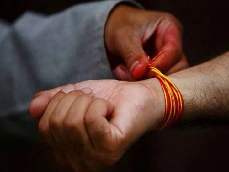 दांए हाथ में लाल धागा बांधे व्यक्ति का चित्र, भारतीय संस्कृति और धार्मिक प्रतीक दिखाते हुए