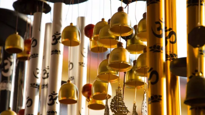 घर की बालकनी में लटके विंड चाइम्स, हवा में बजती मधुर ध्वनि और सकारात्मक ऊर्जा का प्रतीक