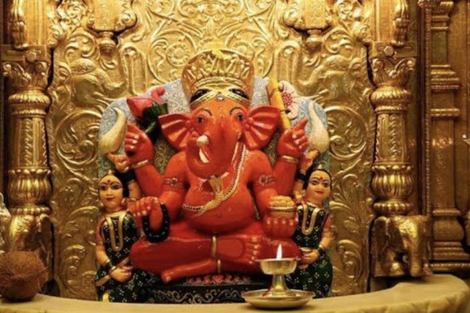 बुधवार के दिन सिद्धिविनायक गणेश मंदिर में श्रद्धालु पूजा करते हुए, मोदक और दूर्वा अर्पित करते भक्त।