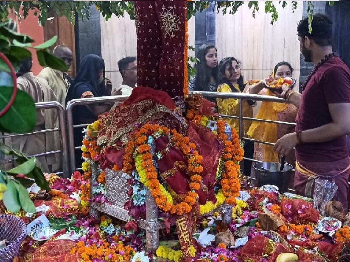 प्रयागराज के मां अलोप शंकरी मंदिर में दिव्य पालने की पूजा करते श्रद्धालु